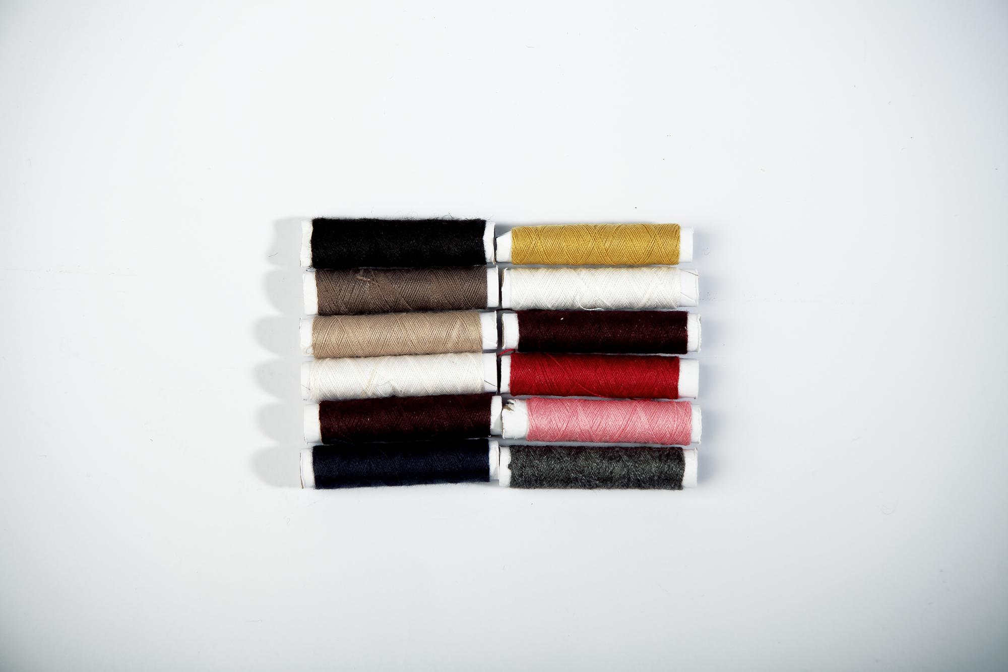 neat rolls of labeled thread and approved swatch cards